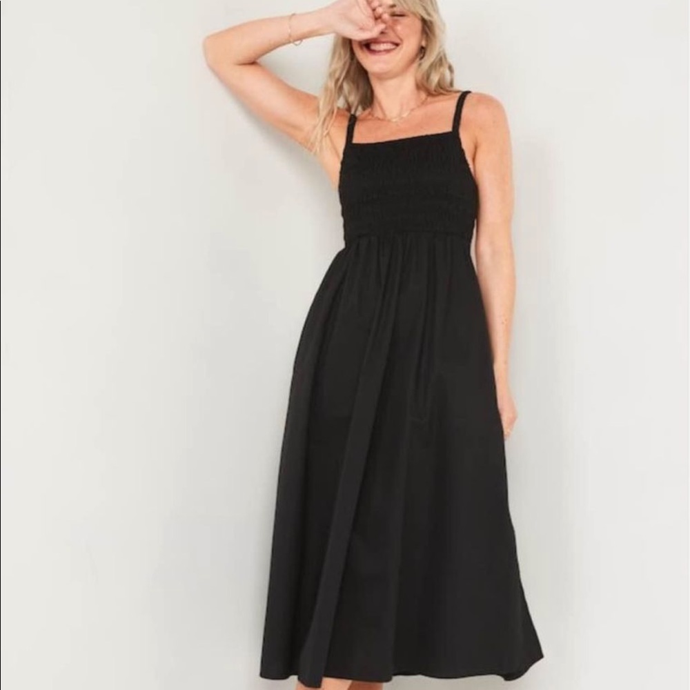 Fit and flare a line black linen dress. Smocking at chest with spaghetti straps.
